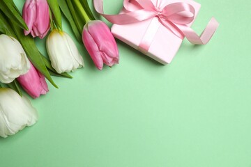 Beautiful fresh tulips with gift box on color background