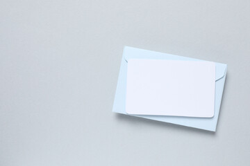 Paper envelope with white card on gray background
