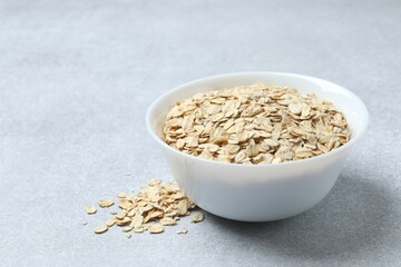 Composition with oatmeal flakes on gray background. Cooking breakfast