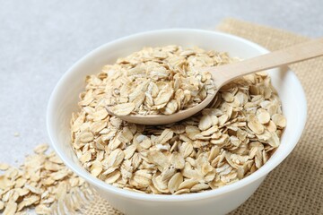 Composition with oatmeal flakes on gray background. Cooking breakfast