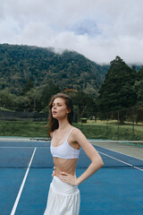 Young athletic woman in sportswear on a tennis court, showcasing determination and confidence...