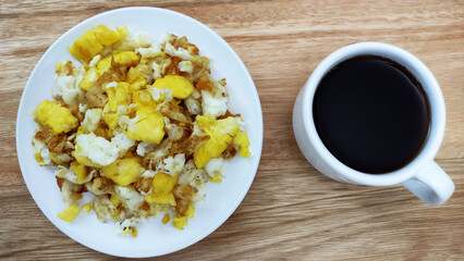 Healthy breakfast with scrambled eggs and coffee cup on the wooden table. 