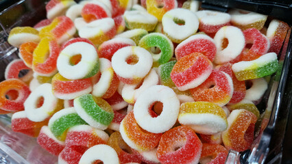 Colored jelly rings with sugar. Jelly candies close-up. Sweets department in the store. Bright jelly chewing candies. Sweets. Candy rings, ready to eat