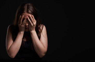 Cover, space and woman in studio or fear for domestic violence, trauma anxiety and terror in dark....