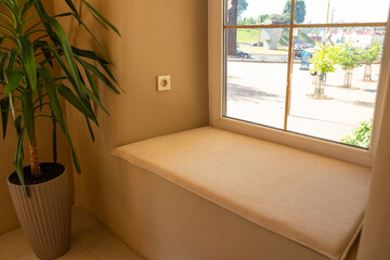 A cozy cafe with a warm, homely atmosphere featuring a soft, wide window sill