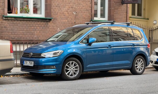 Blue Volkswagen Touran II MPV car parked on street