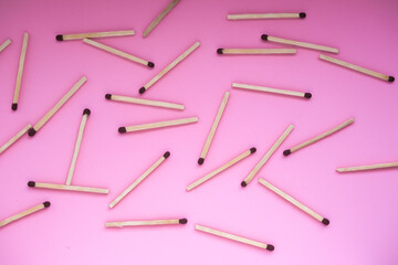 The matches are scattered on a pink background.