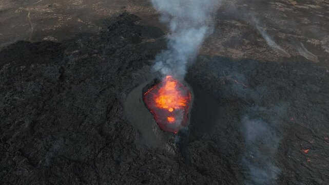 Top down of Stunning volcano eruption, summit crater with boiling magma, aerial directly above view. Powerful force of nature concept.
