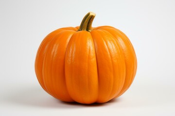 Obraz premium Vibrant orange pumpkin on a plain white background, symbolizing fall harvest and festive celebrations