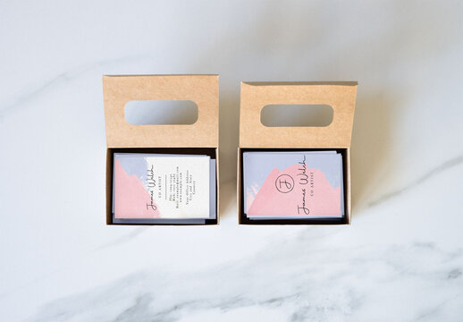 Two blank business cards are displayed, showcasing front and back areas for design options inside their cardbox