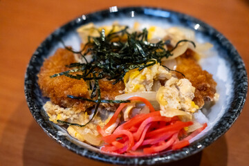 Katsudon, a popular Japanese food. It is a bowl of rice with fried pork cutlet, egg and vegetables