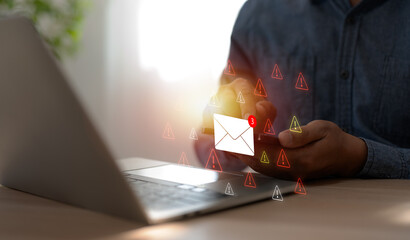 A Businessman working on a laptop open an email with triangle caution warning sign for notification...