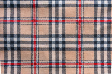 Beige fabric background with red, black and white checkered pattern