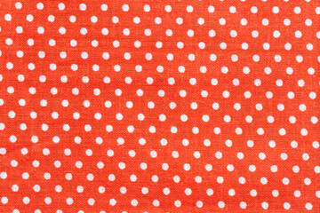Red fabric background featuring white polka dots pattern