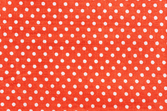 Red fabric background featuring white polka dots pattern