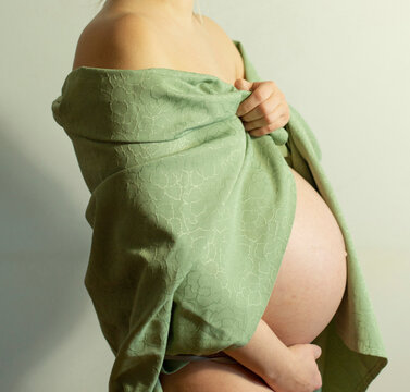 Beautiful shot of pregnant woman in green fabric