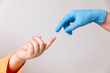 Doctor's hand in a blue medical glove reaching toward female patient's hand offering help isolated...
