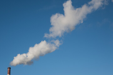 Greenhouse gas emissions into the atmosphere. Smoking power plant chimney, carbon dioxide released into the atmosphere.
