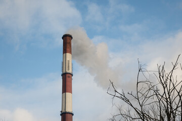 Greenhouse gas emissions into the atmosphere. Smoking power plant chimney, carbon dioxide released...