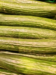 Fresh cucumbers forming a healthy and vibrant green background at the market
