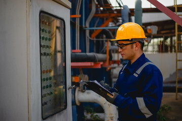 A plumbing inspector is hard at work inspecting the operation of a high-pressure water pump in an...