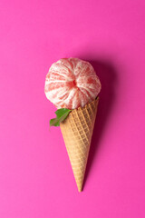 Grapefruit Ice Cream in a Cone on Pink Background