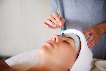 Mask, hands and woman with facial at spa for glowing skin, oil removal or acne treatment. Beautician, clay and skincare at beauty salon for face cleansing, hydration or exfoliation with relaxation