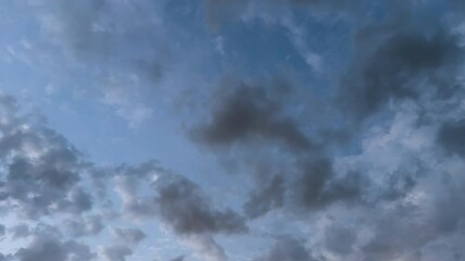 Timelapse show puffy clouds rapidly moving across sky at twilight