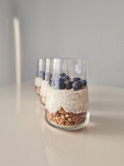 A vibrant yogurt parfait with creamy yogurt, fresh blueberries, crunchy granola, and chia seeds. A delicious and nutritious choice for breakfast or a snack.