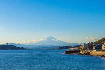 Scenic view of Mount Fuji from the beach at Kamakura, Japan. Mount Fuji behind Enoshima island at Kamakura, Kanagawa, Japan. Kamakura is a city near Tokyo.