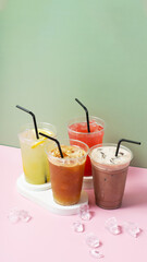 Colourful summer drinks with ice. Lemonade on colored background