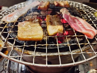 Griiling bacons and pork slices on grill grates