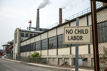 Business Ethics, A factory exterior with a sign stating "No Child Labor," emphasizing the importance of ethical labor practices and industrial safety.