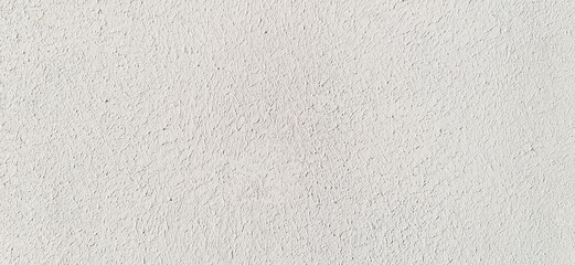 White wall, texture, background. The building wall, painted with water-based paint of white color. Stained, faded surface in white color with paintbrush marks. White but dirty, stained backdrop