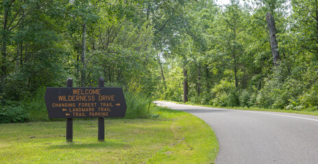 Wooden welcome and directional sign for the Wilderness Drive in the Itasca State Park in Minnesota.