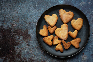 Cookies in the shape of heart baked for St Valentines day on dark blue background 