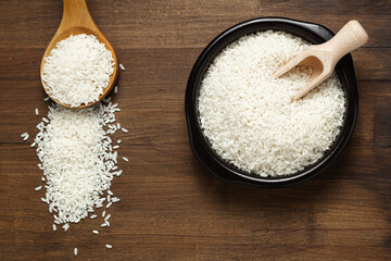 White rice or Jasmine rice in wooden spoon and rustic background. Top view