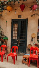 A vibrant doorway beautifully adorned with colorful lanterns and cheerful, inviting chairs captures a cozy ambiance