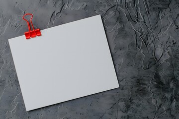 Blank white card clipped with a red binder clip on a dark textured background. Minimalist flat lay composition with copy space for design

