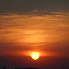 Bright sun against the background of red clouds.