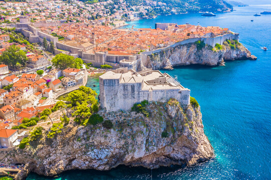 A stunning view from behind Fort Lovrijenac in Dubrovnik, Croatia, capturing the fortress&rsquo;s massive stone walls, the UNESCO-listed Old Town with its historic architecture and the scenic marina