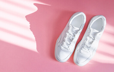 White sneakers on a pink background.
