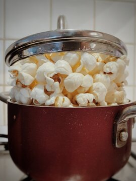 Naklejki Popcorn in small red pot with lid on top