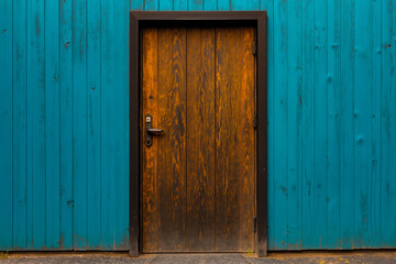 A wooden door on a blue wooden wall