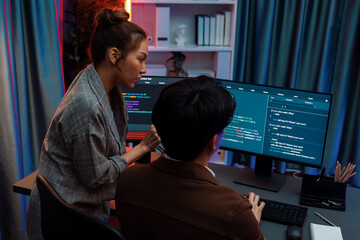 Smart IT developer looking at coding program application on computer screen of online website at...