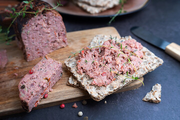 Snack featuring liver pate spread on a crispbread, appetizer.