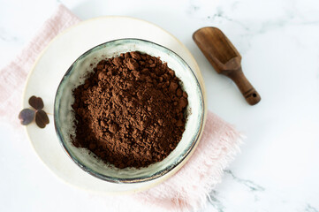 A bowl filled with rich, dark cocoa powder, showcasing its fine texture.