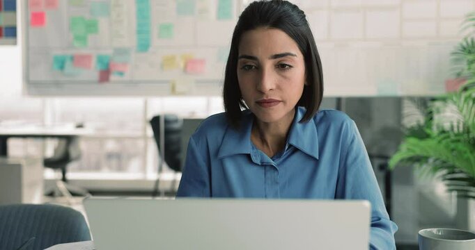 Brazilian woman using laptop, engaged in data analysis, brainstorming ideas for project, researching information, editing document, or learning new skills through online course, develop presentation