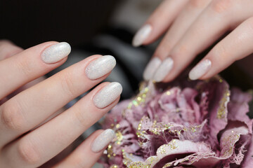 Women's nails with a beautiful pink manicure with glitter. Nail design. Manicure with gel polish...