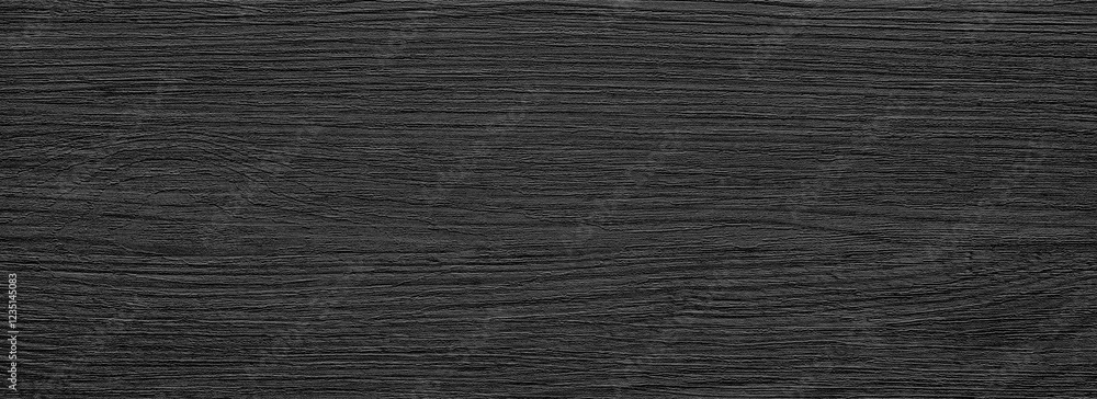 Aufkleber a black wooden surface with a grainy texture. the surface is dark and has a rough texture